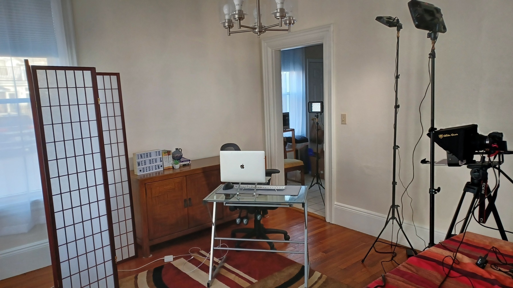 Teleprompter, lights, desk, chair, and screen.